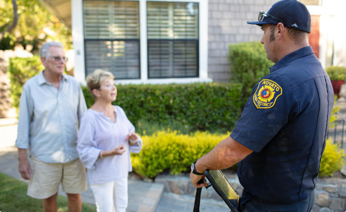 A Novato Fire representative meets with homeowners to discuss wildfire mitigations.